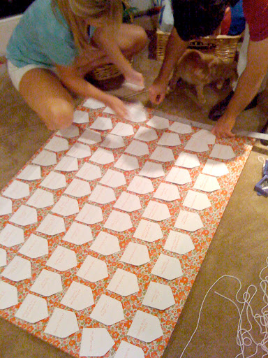 Here my sister and Craig are placing the envelopes on the pin-board. We pinned yarn down first in a grid so that we'd know where each envelope would go, then made sure they were alphabetized before pinning them in place. Here my sister and Craig are placing the envelopes on the pin-board. We pinned yarn down first in a grid so that we'd know where each envelope would go, then made sure they were alphabetized before pinning them in place.