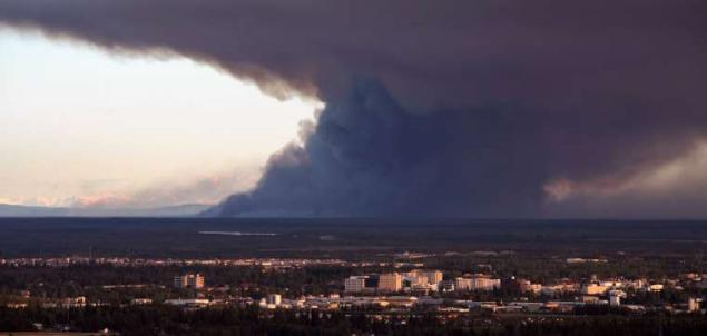 In this Wednesday, 22 August 2012 photo, smoke from the Dry Creek Fire spreads through the sky after it rekindled from a June 23 lightning strike in Fairbanks, Alaska. The fire, 25 miles south of Fairbanks, Alaska, was mapped by a surveillance flight Wednesday. At 28,251 acres, the fire has doubled in size since Sunday. Sam Harrel / AP Photo / Fairbanks Daily News-Miner