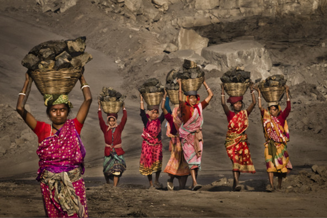 Local villagers carry coal after having scavenged the coal illegally from an open-cast coal mine in the village of Jina Gora on 11 February 2012 near Jharia, India. Villagers in India's Eastern State of Jharkhand scavenge coal illegally from open-cast coal mines to earn a few dollars a day. Photo: Daniel Berehulak / Getty Images AsiaPac