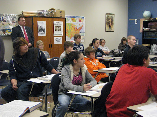 A member of the governor's security staff stands at the back of the room as students in this history class in Clever High School listen to the governor talk about World War I. (Photo credit: Jennifer Moore)