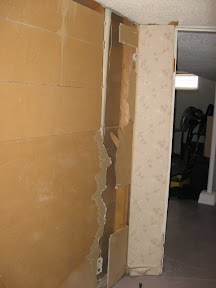 When installing a central vac, they didn't feel like patching the hole. Instead, they just put up more panelling over top.
