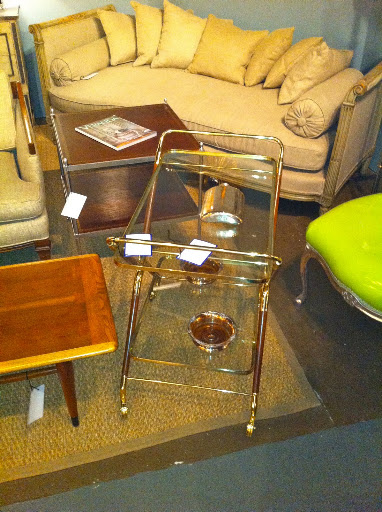 A gilded glass bar, next to a great beige divan.