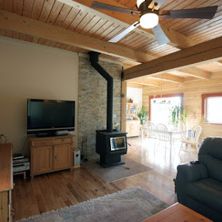Living room with wood stove and dining area in background  (Foto by Ted Grant)