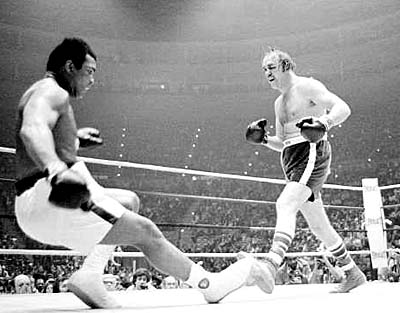 Defending heavyweight champion Muhammad Ali goes down in the ninth round of the title bout against challenger Chuck Wepner, from Bayonne, N.J., at the Richfield Coliseum, in Cleveland, Ohio, on March 24, 1975. Ali tripped over Wepner's foot, but the referee ruled it as a knockdown. Ali later knocked out Wepner in the 15th round to retain his title. (AP Photo)