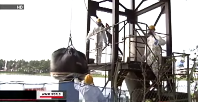 Workers move a load of radioactive sludge. Nearly 50,000 tons of sludge at water treatment facilities has been found to contain radioactive cesium as the result of the accident at the Fukushima Daiichi nuclear power plant. Over 1,500 tons is so contaminated that it cannot be buried for disposal. NHK 