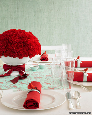Bold accents such as a carnation centerpiece or red napkins pop against white table linens and plates. Bold accents such as a carnation centerpiece or red napkins pop against white table linens and plates.