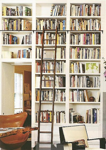 I like how the ladder is offset with it's dark color against the bright white of the library shelves. (Pinterest)