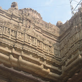 Ganesha, in front central niche, accompanied by two female attendants. On leftmost side is a niche showing a horse and a human figure, what it could be representing? Above Ganesha niche is shown a goddess holding munda (human skull), parasu and trishula. This kind of middle tier image is common across all the side of the roof over the mandapa.