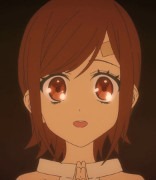 A close up of Saki's face as she prays while staring into a holy fire during her initiation