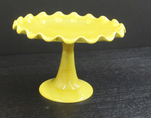 The full view of this bright-yellow cake stand.
