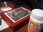 It couldn't be easier: Select image, smear some Mod Podge on the back, flatten against surface, and glaze it over with more Mod Podge.