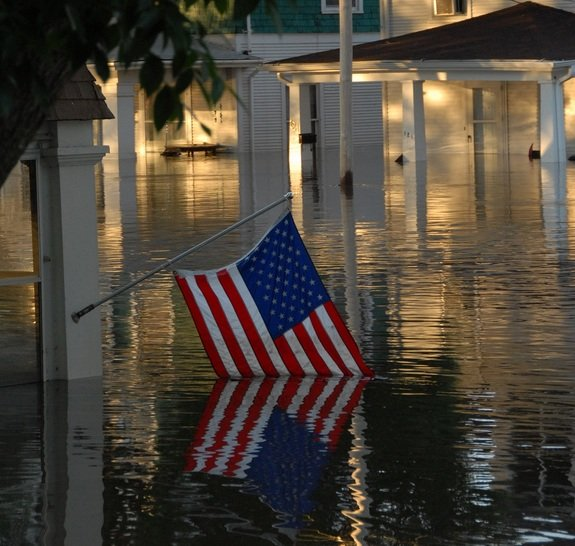 A submerged American flag shows the devastation of a flood in downtown Cedar Rapids, Iowa, 13 June 2008. Photo By U.S. Air Force / Staff Sgt. Oscar M. Sanchez-Alvarez
