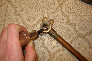 After gingerly weakening the metal in a few spots with the hacksaw, I pried it out with needlenose pliers and screwdriver
