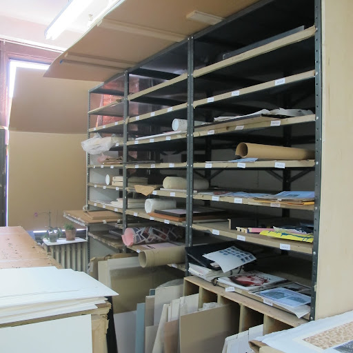 Shelves organize some pieces waiting to be framed.