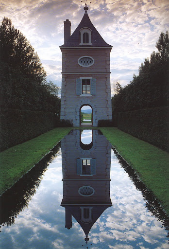 The Pigeonnier's archways and reflecting pool frame the fields and hills of Lac des Cygnes.