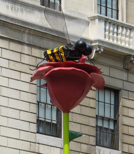A fiberglass and resin bee perches atop a beautiful bloom.