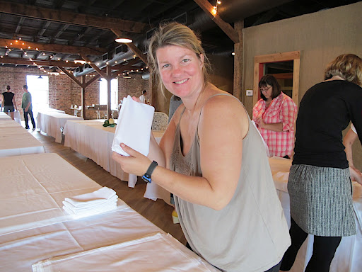 Tables were dressed with tablecloths, friends and family folded napkins, and later set out centerpieces and final touches.