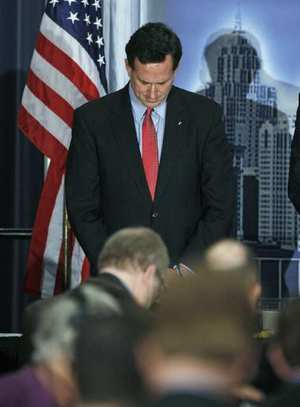 Rick Santorum bows his head during a prayer before addressing the Detroit Economic Club, 16 February 2012. Bill Pugliano / Getty Images