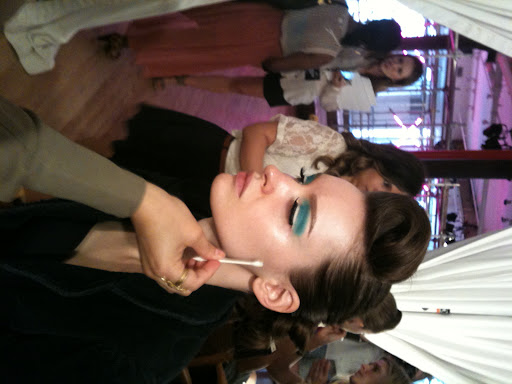 White kohl eyeliner was drawn along the top lid to open up the eyes, and a dramatic whoosh of mint green and blue shadow was applied in a boxy, wavy shape from the inner corner, ending in a winged tail.