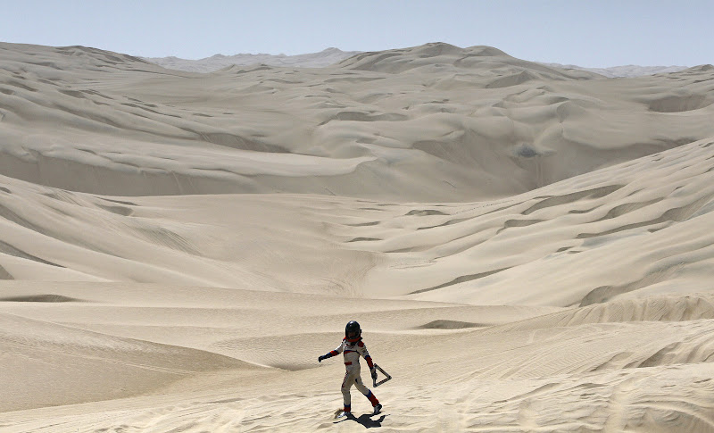 Erik Wevers, Dutch co-driver of the Mitsubishi driven by Fabian Lurquin, from Belgium, walks along the desert after their car got stuck in the sand during the 12th stage of the 2012 Argentina-Chile-Peru Dakar Rally between Arequipa and Nazca in Peru, Friday, Jan. 13, 2012. (AP Photo/Martin Mejia)