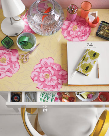Her work will always be more pleasant with flowers on the desk. Place a swath of bloom-themed wallpaper (use double-sided tape if the edges curl) on a desk, and then top it with a piece of custom-cut glass. (marthastewart.com) Her work will always be more pleasant with flowers on the desk. Place a swath of bloom-themed wallpaper (use double-sided tape if the edges curl) on a desk, and then top it with a piece of custom-cut glass. (marthastewart.com)