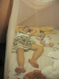 Lora and Matimu are taking a nap under the mosquito net, to avoid bites and potential malaria! IMG_1420.jpg