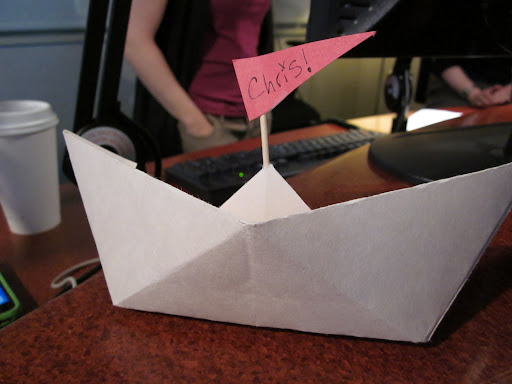 Once the boats are folded, attaching a tootpick mast and paper flag transforms them into placecards.  You could step this step - and the sharp objects - and just write on the boats.