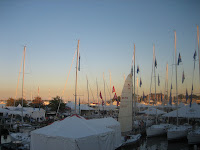 The small boat in the right foreground has raised sails in prep to sail out - a boat show tradition
