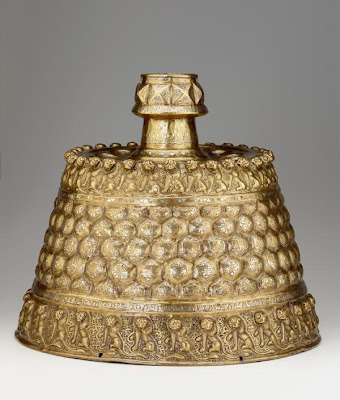 Candlestick | Origin:  Afghanistan | Period: ca. 1150-1200 | Details:  This monumental candlestick is a tour de force of Persian metalwork technique. Except for a cylindrical piece between the socket and the neck, its form was constructed from a single sheet of brass that was hammered from both the front and the back. The relief decoration was also raised from the back in a technique known as repousse. Details were added to the surface by cutting grooves and recesses into the brass (chasing) and then inlaying them with pieces of copper and silver. The development of this form of surface decoration, which originated in eastern Iran during the twelfth century, was one of the most important technical and artistic achievements of the Seljuq period (1038-1194). It allowed for the transformation of brass vessels into luxury wares, which could then compete with the finest vessels fashioned in gold and silver. | Type: Brass, hammered and chased, inlaid with copper, silver, and black organic material | Size: H: 40.3  W: 47.7   D: 47.7  cm | Museum Code: F1951.17 | Photograph and description taken from Freer and the Sackler (Smithsonian) Museums.