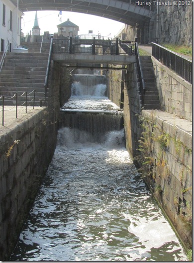This photo is the old lock system, showing the Flight of Five. Five locks brought the boats carrying thousands tons of cargo through the canal system so that they could operate businesses in New York City and Buffalo and places beyond that received the products. The current two-lock system runs adjacent to these old locks. Lockport, N.Y., Lock System