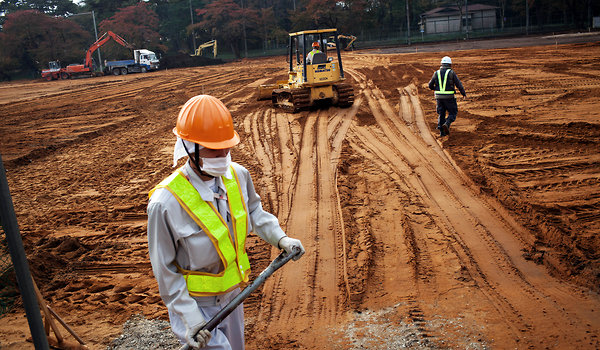 Workers replace soil as part of a decontamination effort at Soma agricultural high school in Fukushima. Ko Sasaki for The New York Times