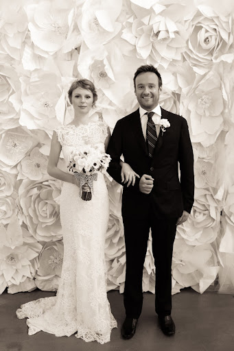 Lisa and Alex pose in front of our paper flowered covered photo booth.