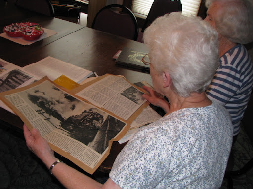 Betty Perry, president of the Cabool History Society, looks over old documents and articles with a fellow member of the Cabool History Society.