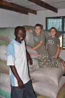 The maize in storage in Magambua. Josh and Drew pose with Micah, a friend from Singida who arranged the purchase and delivery.