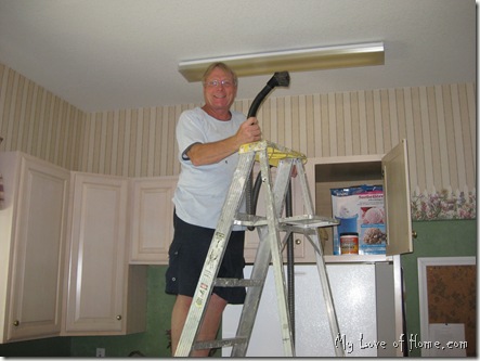 man cleaning light stripped wallpaper