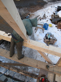 Michael shaves down a rafter before placing it in the step lap.