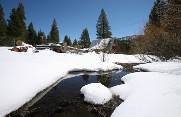 This 30 April 2010 file photo shows a stream seen running through snow covered banks near the site of the Department of Water Resources snow survey at Echo Summit, California. A new report released on 7 August 2013 found climate change is affecting California. Over the past century, snowpack runoff has decreased due to warmer winters and earlier arrival of spring. Photo: Rich Pedroncelli / Associated Press