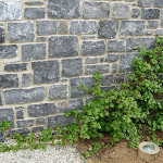 Stone wall of unsorted rubble stone trimmed for laying