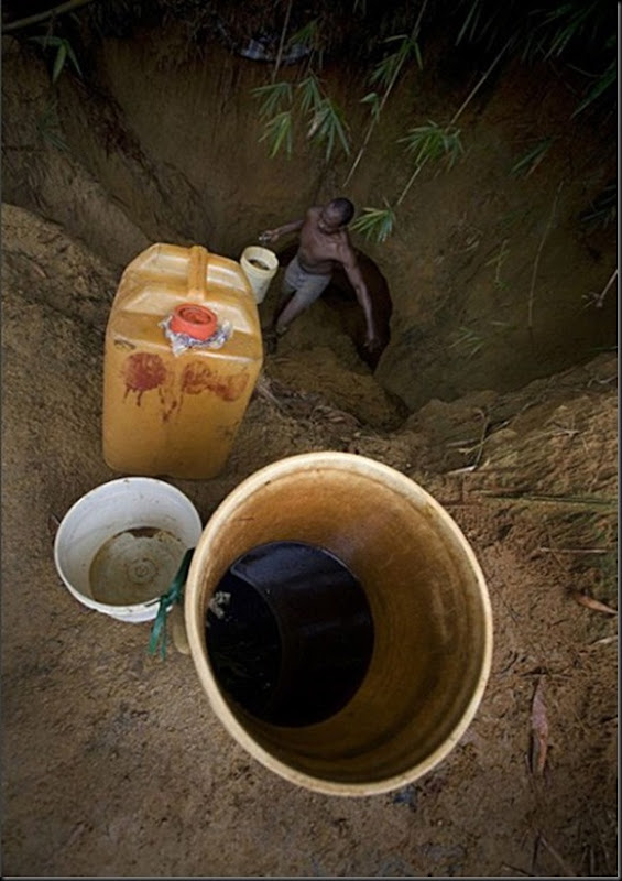 A man collects oil, in order to sell it on the black market.