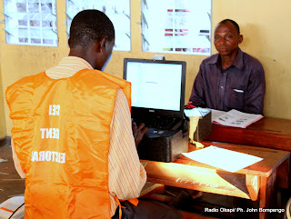 En avant plan, un operateur de la CENI entrain d'enregistrer un homme venu pour obtenir une nouvelle cartre d'électeur ce 7/05/2011 à Kinshasa. Radio Okapi/ Ph. John Bompengo