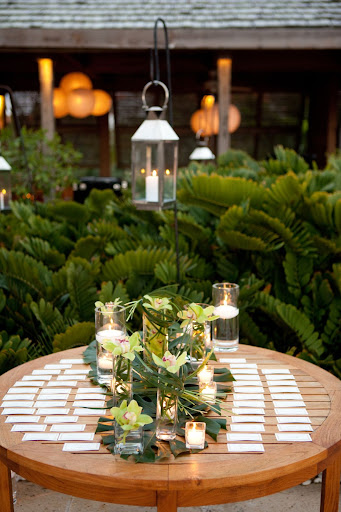 The escort-card table was decorated with orchids, candles, and tropical leaves. The escort-card table was decorated with orchids, candles, and tropical leaves.