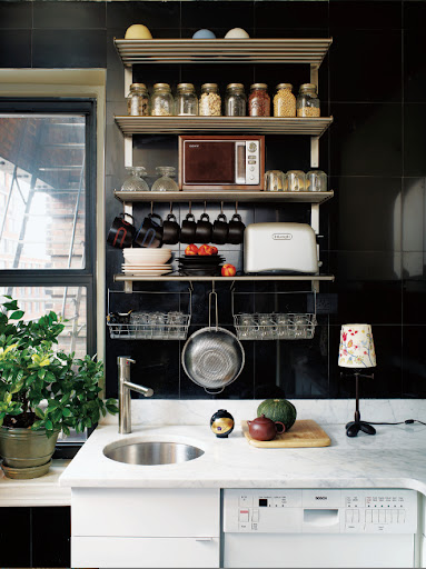 These black marble floor tiles from The Home Depot make a great and easy to clean backsplash.  The open shelving stocked with tools and supplies looks great against the dark tile.