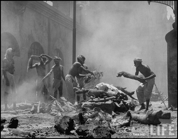 Men adding wood & straw to funeral pyres in preparation for cremation of many corpses after bloody rioting between Hindus and Muslims[4]