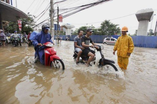 Motorcyclists ride on a flooded street in Hanoi on Sunday. Strong wind and rain in northern Vietnam unleashed by Typhoon Kai-Tak have killed at least 17 people, damaged thousands of houses and submerged valuable crops, authorities said Monday, 20 August 2012. Reuters