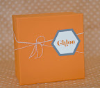 Covered in palette-matching paper and tied with gray and white baker's twine and a hexagonal tag, this gift box is the perfect thing to hold your bridesmaids' presents.