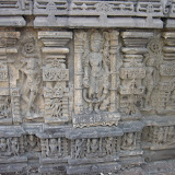 Who its could be in the central niche, shown with four hands carrying a kamadalu in one lower hand and other lower hand is in varada pose. The above two hands seems to be carrying lotus stems. If these are lotus stems, then it should be Surya however the elephant like animal down the feet does not agree with this.