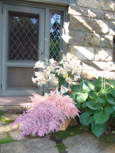 Astilbe and trumpet lilies waiting to be arranged outside the door of the flower room.