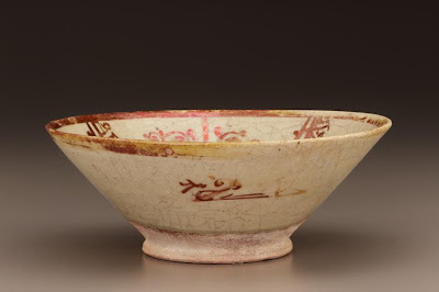 Bowl | Origin:  Egypt | Period: 12th century  Fatimid period | Details:  Figural representations also played a prominent role in luster-painted ceramics from twelfth century Egypt. Although the vessels were made from coarser clay than the earlier Iraqi examples, the decoration, like much of the art of the Fatimid period (909-1171), tended to be more animated and naturalistic. The plate is also embellished with an inscription bestowing good wishes on its anonymous owner. The small bowl is entirely decorated with individual words, such as "pleasure," "happiness," and "wealth." Using an ornate kufic, or angular script, the potter has drawn on the decorative qualities of the written words to create a rather unusual design. | Type: Earthenware painted over glaze with luster | Size: H: 8.9  W: 21.0   D: 21.0  cm | Museum Code: F1936.2 | Photograph and description taken from Freer and the Sackler (Smithsonian) Museums.