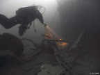 Brummer: diver inspecting scrap on the bottom by the hull