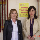 Maria Luisa con Raquel ante el cartel que anuncia la actividad, financiada por Bancaja.
